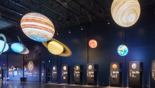 Salle d’exposition sur le système solaire dans un musée scientifique, planètes suspendues et panneaux éducatifs
